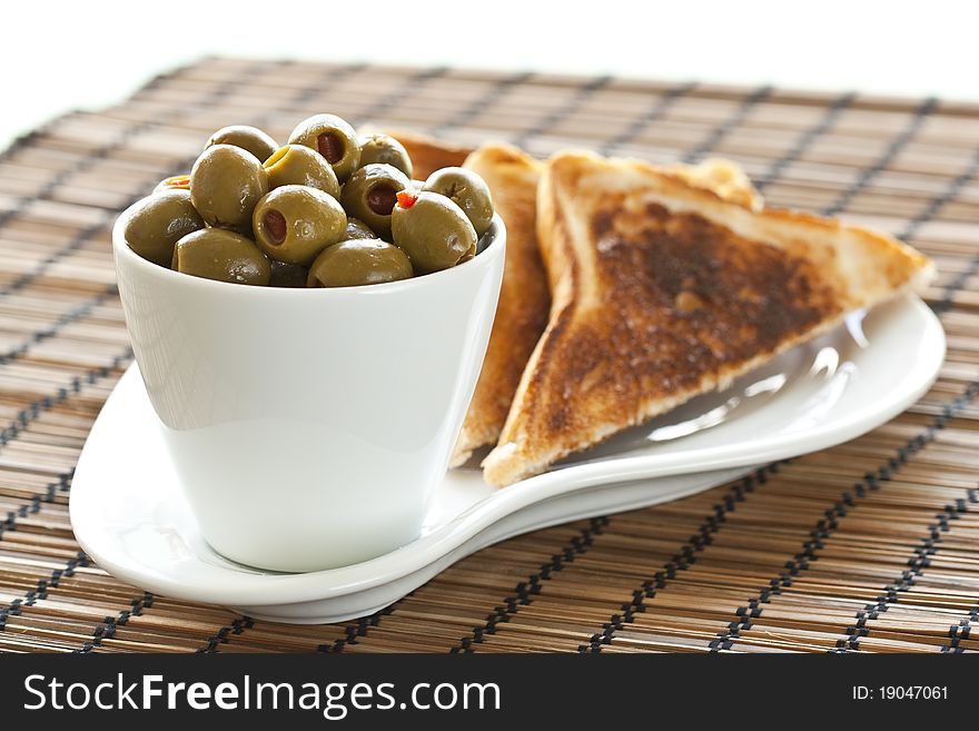 This is a heap of olives and some toasted bread on a nice plate. This is a heap of olives and some toasted bread on a nice plate