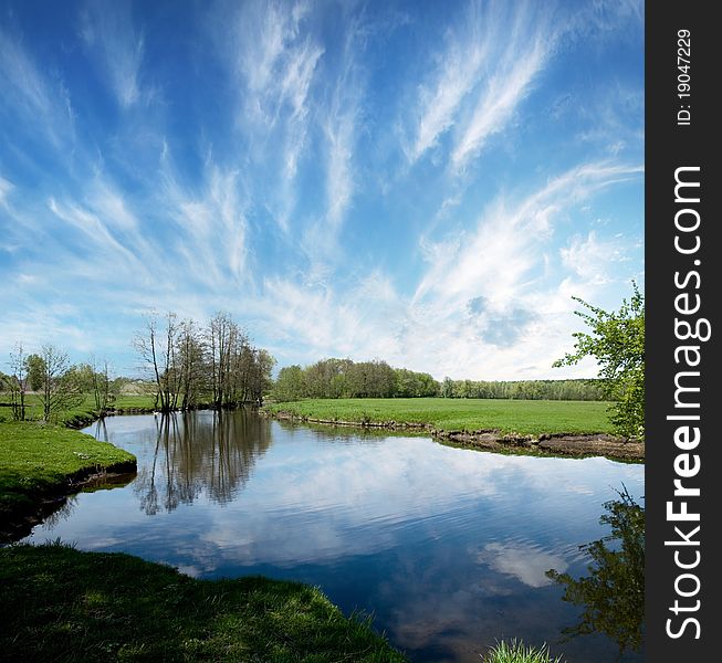 Lake in countryside in the spring time. Bly sky with light fleecy clouds. Lake in countryside in the spring time. Bly sky with light fleecy clouds.