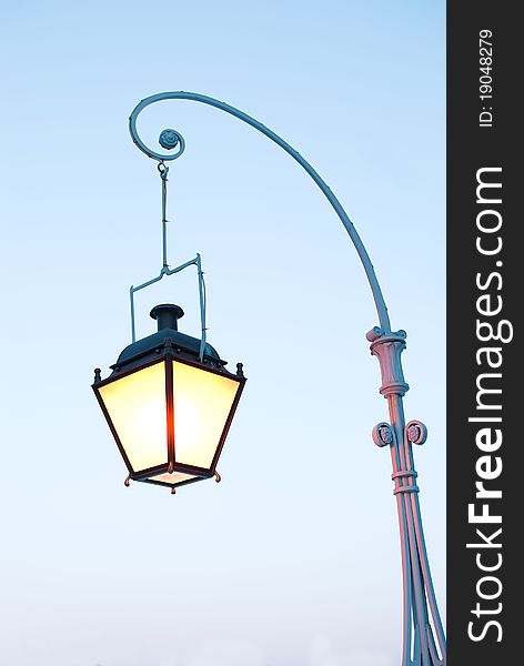 Lighting retro lamppost on the blue night sky background