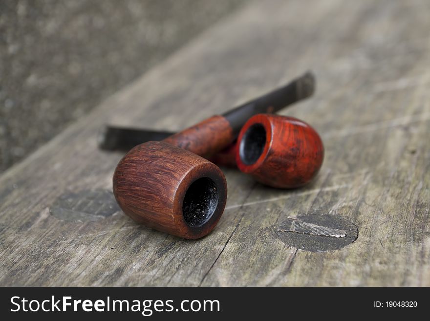 Two tobacco pipes on the wooden bench