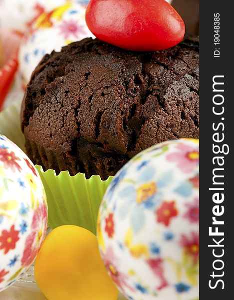 Chocolate muffin decorated with easter eggs closeup. Chocolate muffin decorated with easter eggs closeup