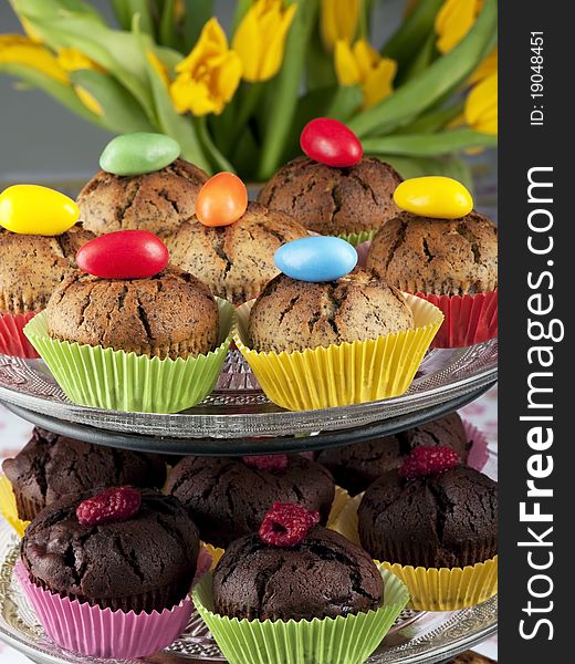 Muffins decorated with easter eggs and tulips in the background