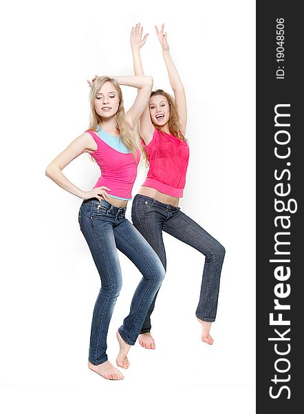 Two young attractive women dancing over white. Two young attractive women dancing over white