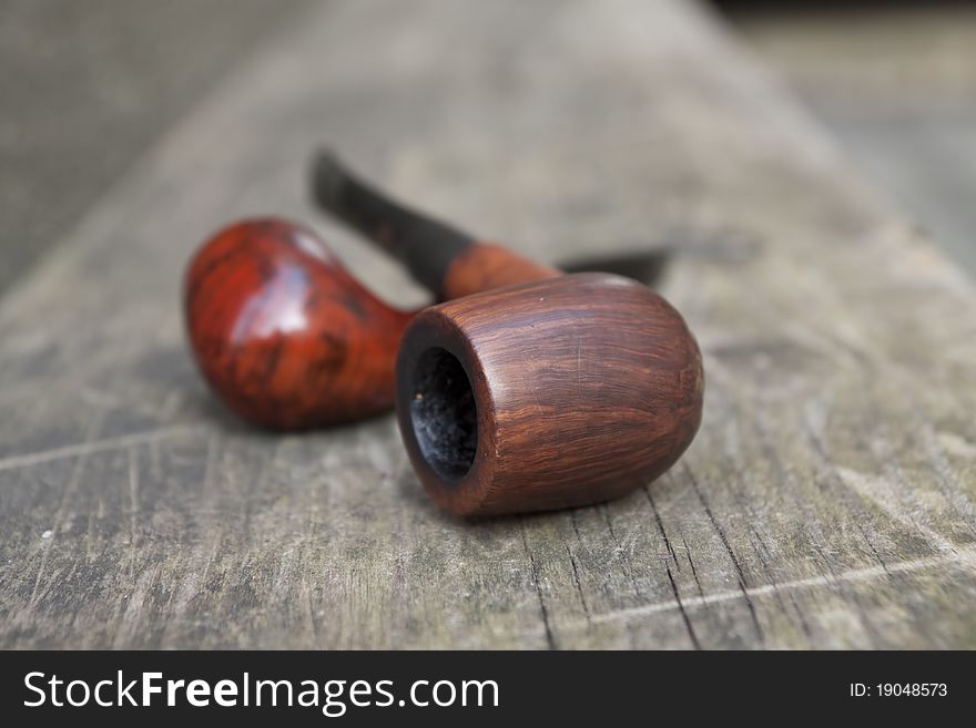 Two tobacco pipes on the wooden bench