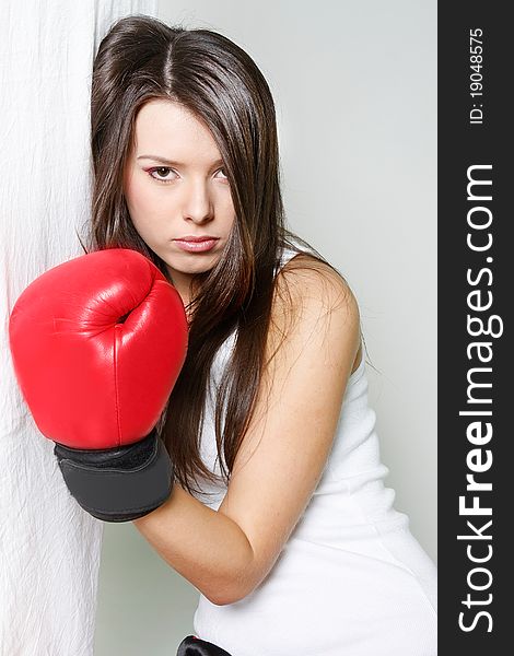 Studio portrait of female boxer near white wall