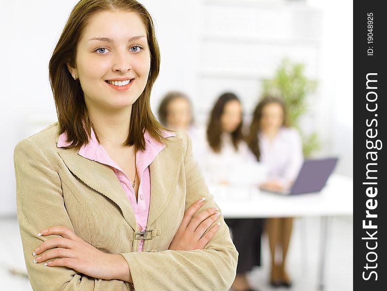 The beautiful business woman with a team on a back background