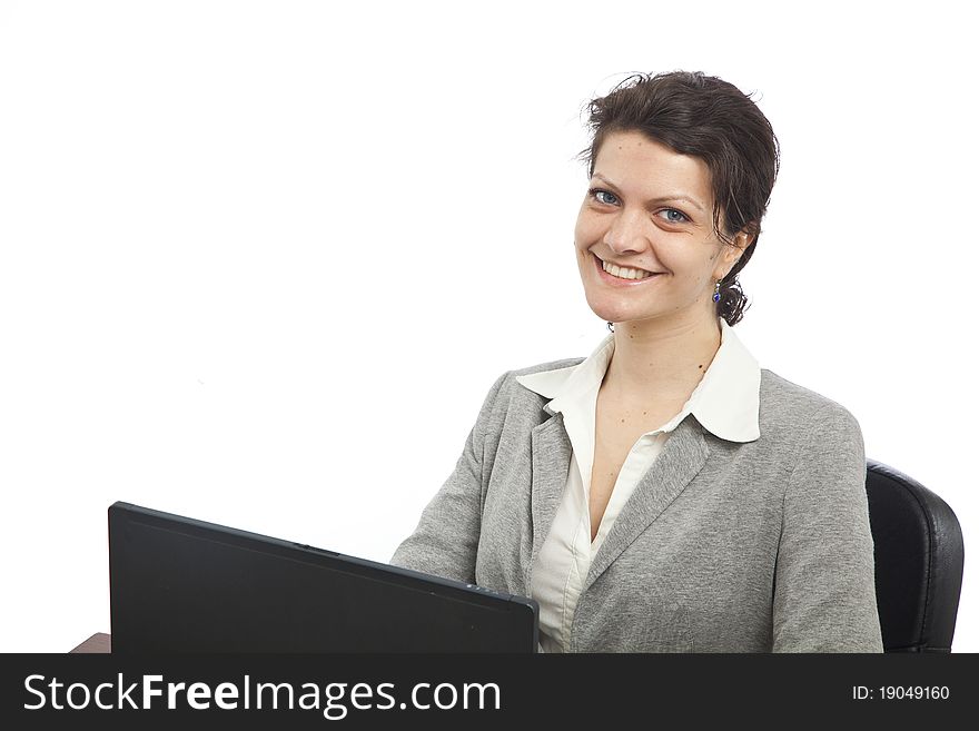 Businesswoman smiling at her desk with laptop, landscape orientation. Businesswoman smiling at her desk with laptop, landscape orientation