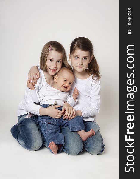 Portrait of twin sisters with small brother on white background. Portrait of twin sisters with small brother on white background