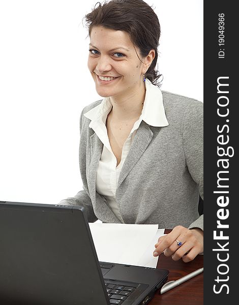 Smiling businesswoman on her office desk, portrait orientation