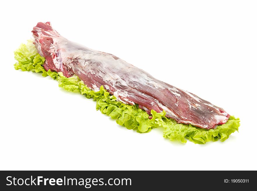 Beef tenderloin on bed of lettuce isolated on white background