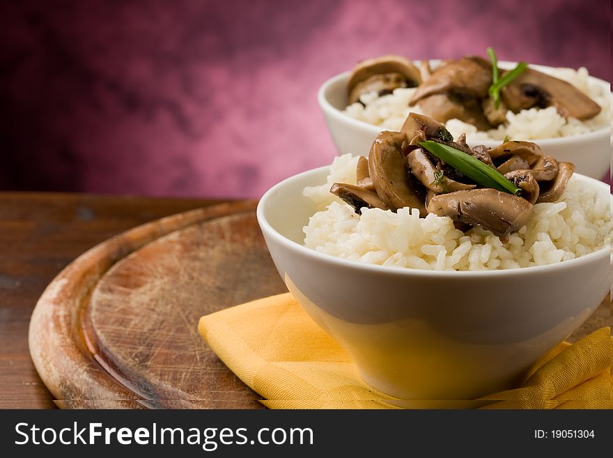 Photo of delicious risotto with mushrooms on wooden table