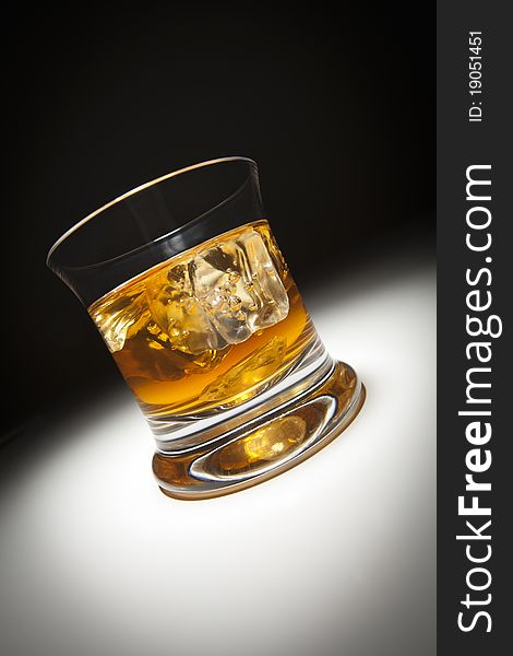 Glass of Whiskey or Other Alcoholic Drink and Ice Under Spot Light. Glass of Whiskey or Other Alcoholic Drink and Ice Under Spot Light.