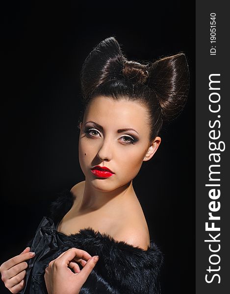 Portrait of beautiful girl with bow coiffure on black