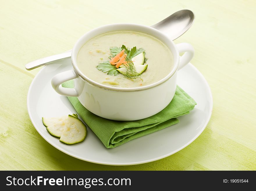 Photo of vegetarian vegetable soup on green wooden table with different vegetables arround