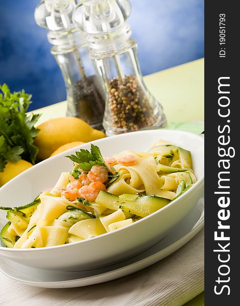 Photo of delicious italian pasta with zucchini and shrimps