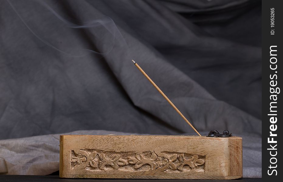 Carved wooden incense burner against dark background. Carved wooden incense burner against dark background.