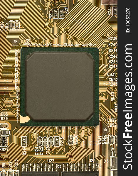 Black chip processor with green frame surrounded by brown orange circuit board - motherboard. Black chip processor with green frame surrounded by brown orange circuit board - motherboard