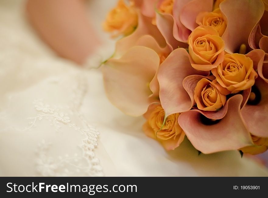 Nice orange bouquet with rose and callas in bride hands