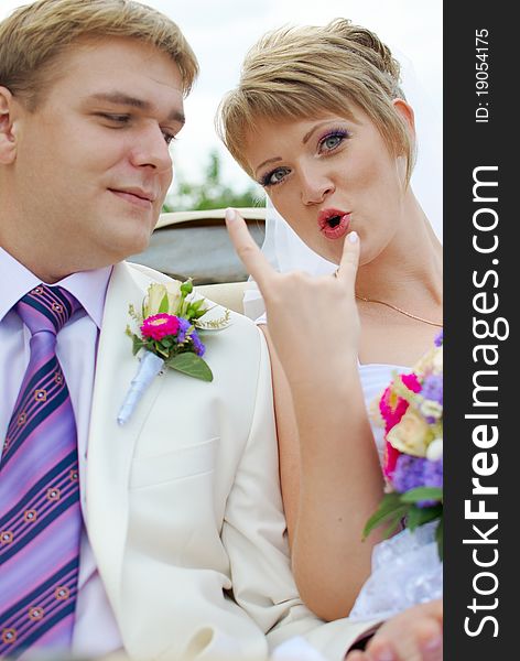 Bride and groom fooling with funny expressions outside