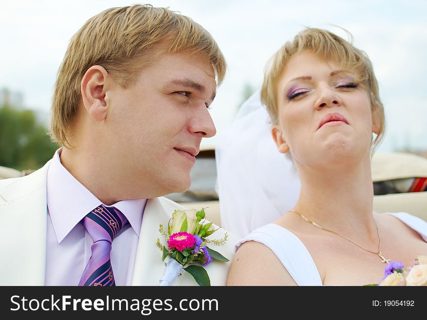 Bride and groom fooling with funny expressions outside