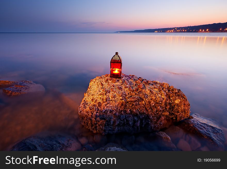 Sunset on the rocky coast with red lantern