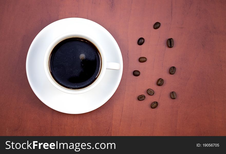 White cup of coffee on wooden background. Top view