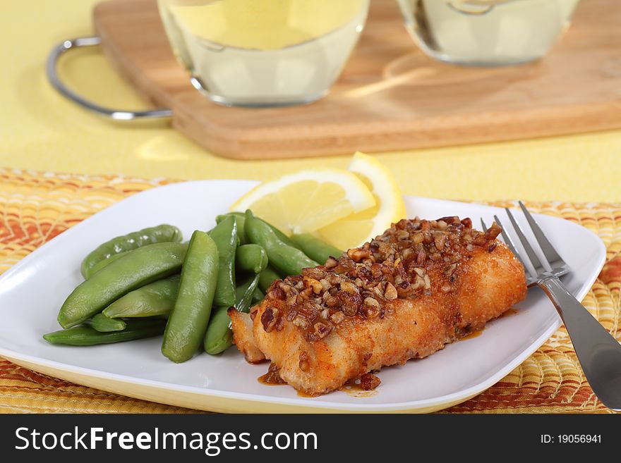 Fried cod fish fillet with snap peas and lemon slice. Fried cod fish fillet with snap peas and lemon slice