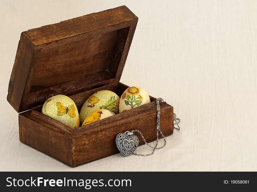 Easter eggs in a box with a silver heart. Easter eggs in a box for jewelry with a silver heart-shaped pendant. Eggs are clad with commemorative Easter samples of chickens, sunflowers, flowers . Easter eggs in a box with a silver heart. Easter eggs in a box for jewelry with a silver heart-shaped pendant. Eggs are clad with commemorative Easter samples of chickens, sunflowers, flowers ...