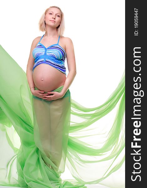 Beautiful young pregnant blonde woman with green transparent cloth in studio. Beautiful young pregnant blonde woman with green transparent cloth in studio