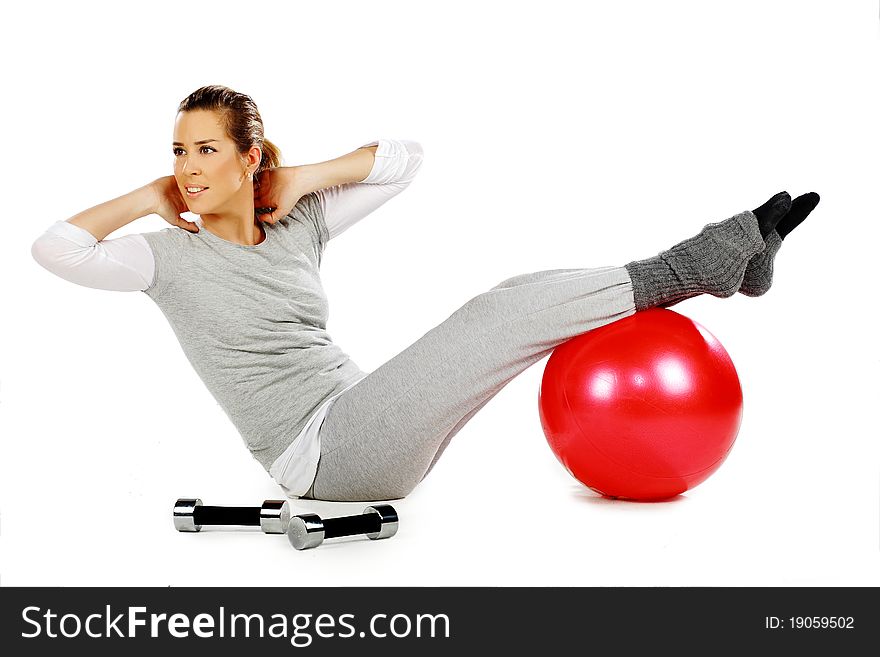 Girl sitting and exercising with a red ball
