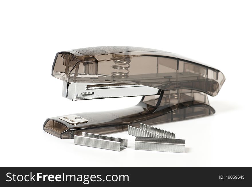 Transparent grey office stapler and staples isolated on white