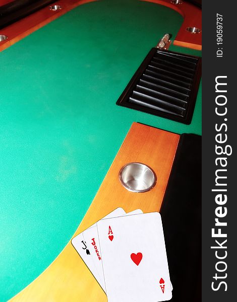 Green casino table with copy space and the jack of spades joker and ace of hearts representing a blackjack game. Green casino table with copy space and the jack of spades joker and ace of hearts representing a blackjack game