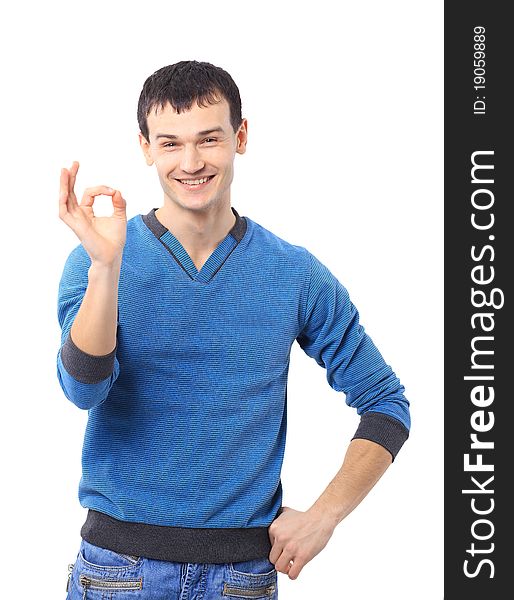 Portrait of a smiling handsome young man gesturing ok sign against white background