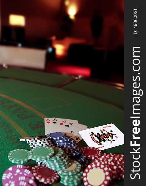 Green casino table with chips and four aces in a poker game and a joker in the pack. Green casino table with chips and four aces in a poker game and a joker in the pack