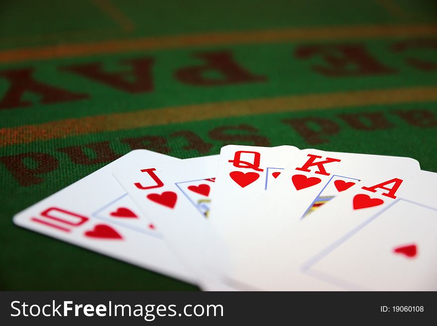 Green casino table with a hand of a royal flush in a poker game. Green casino table with a hand of a royal flush in a poker game