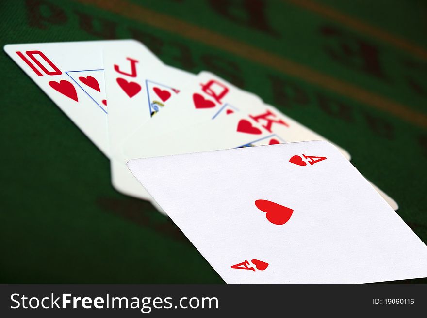 Green casino table with a hand of a royal flush in a poker game. Green casino table with a hand of a royal flush in a poker game