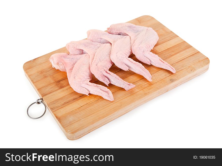 Raw chicken wings on wooden board