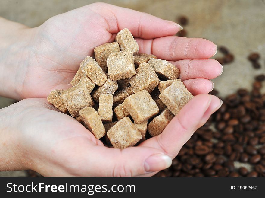 Women's hands hold cane sugar close up