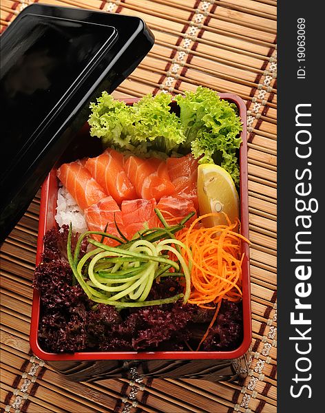 Japanese cuisine, fresh fish and vegetables in a box