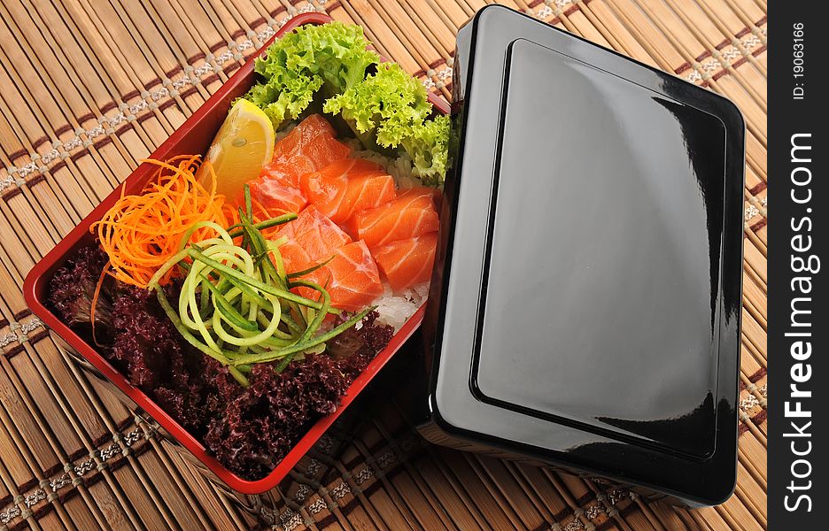 Japanese cuisine, fresh fish and vegetables in a box