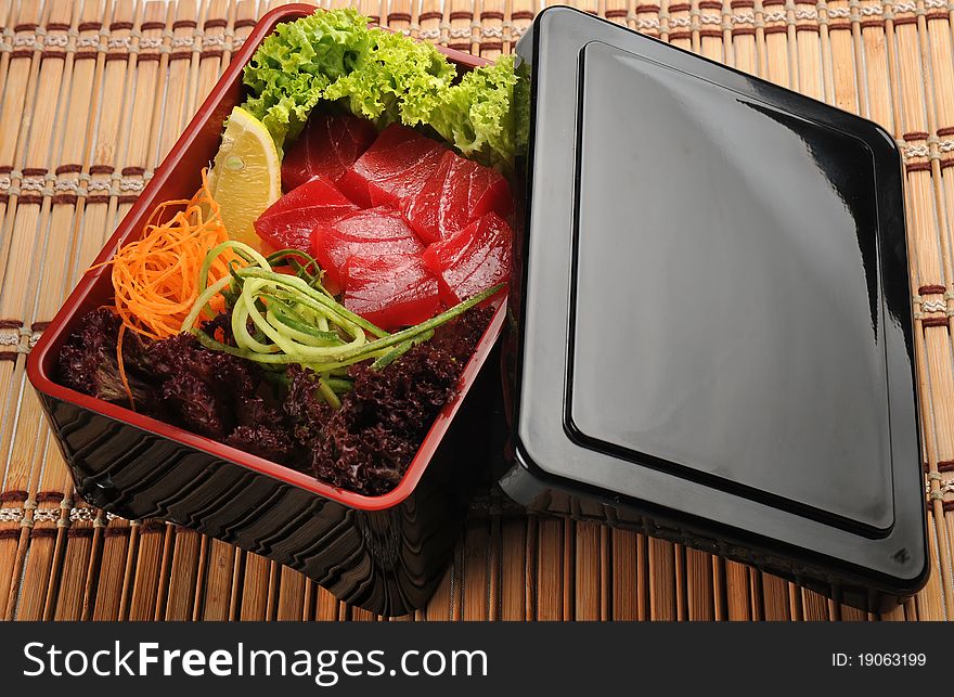 Japanese cuisine, fresh fish and vegetables in a box