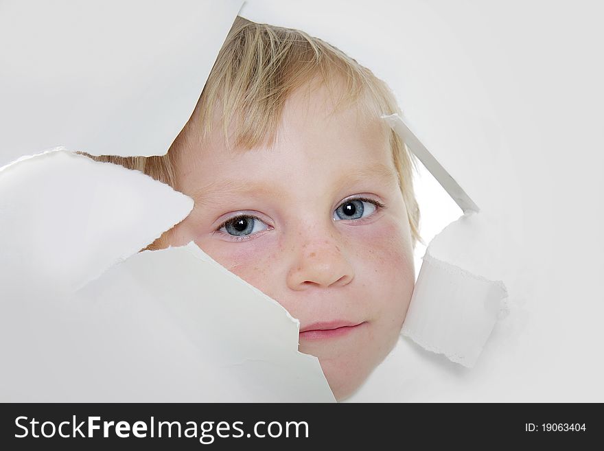 Cute child looking out from hole in paper