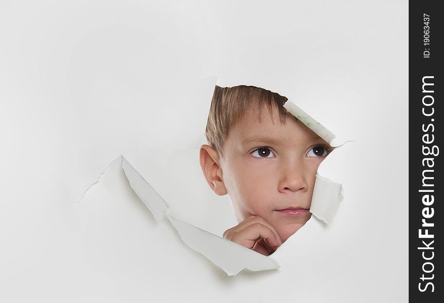 Child looking out from hole in paper