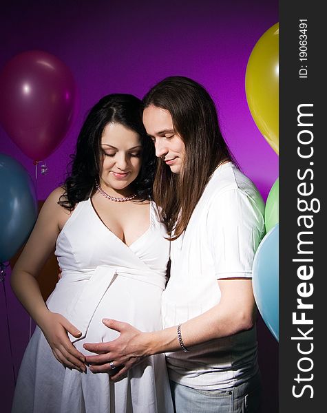 Happy pregnant couple posing in studio