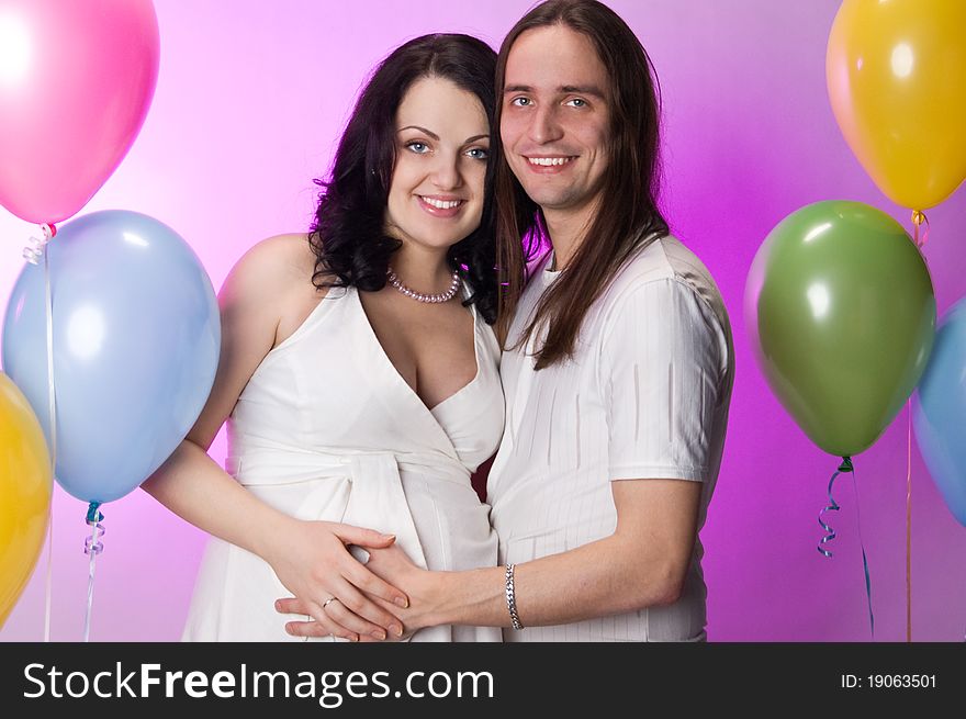 Happy young pregnant couple posing in studio. Happy young pregnant couple posing in studio