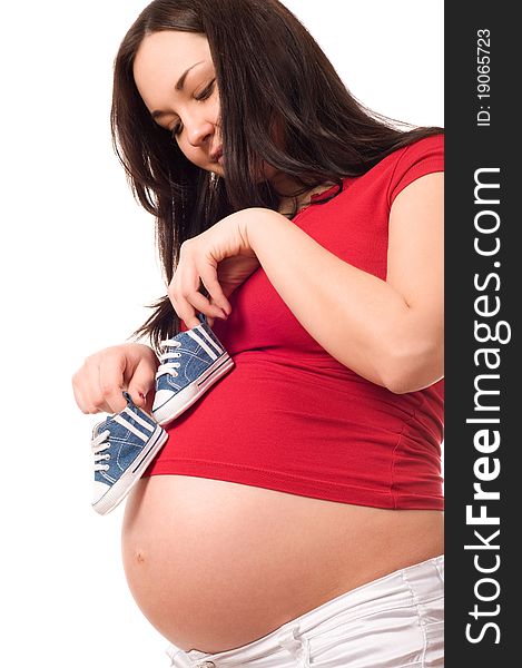 A Pregnant Woman Holding Baby Shoes