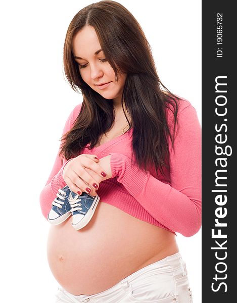 A Pregnant Woman Holding Baby Shoes