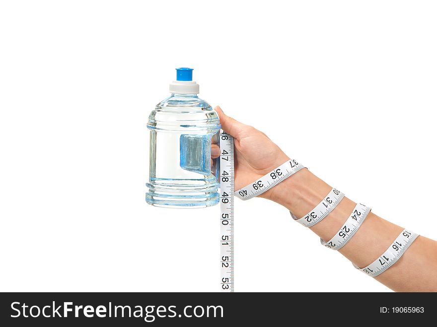 Diabetes diet concept tape measure twisted around woman hand, wrist and measuring blue bottle of drinking sparkling mineral water on a white background. Diabetes diet concept tape measure twisted around woman hand, wrist and measuring blue bottle of drinking sparkling mineral water on a white background