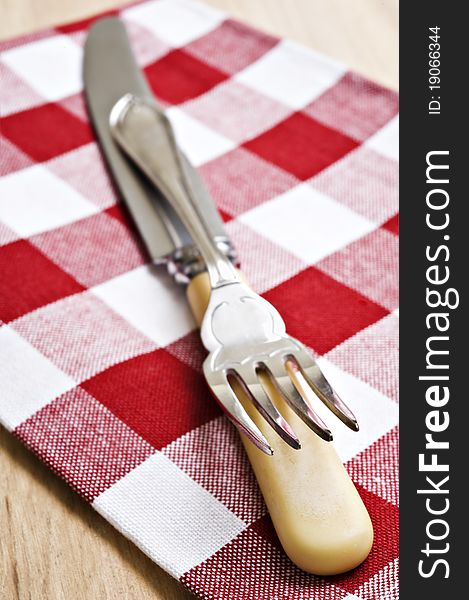 Antique knife and fork on a red and white cloth. Antique knife and fork on a red and white cloth