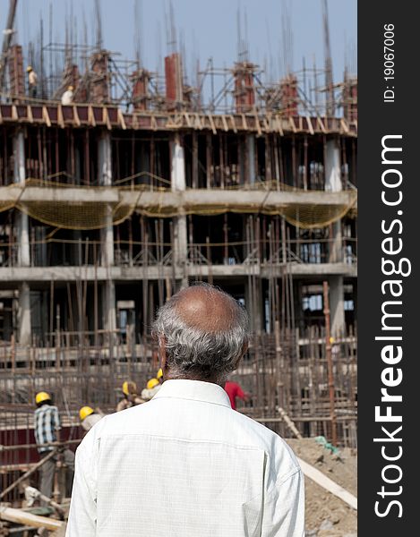 An old Indian man inspecting a construction work. An old Indian man inspecting a construction work